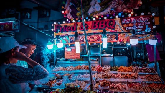 customer choosing raw kebab in street stall at night