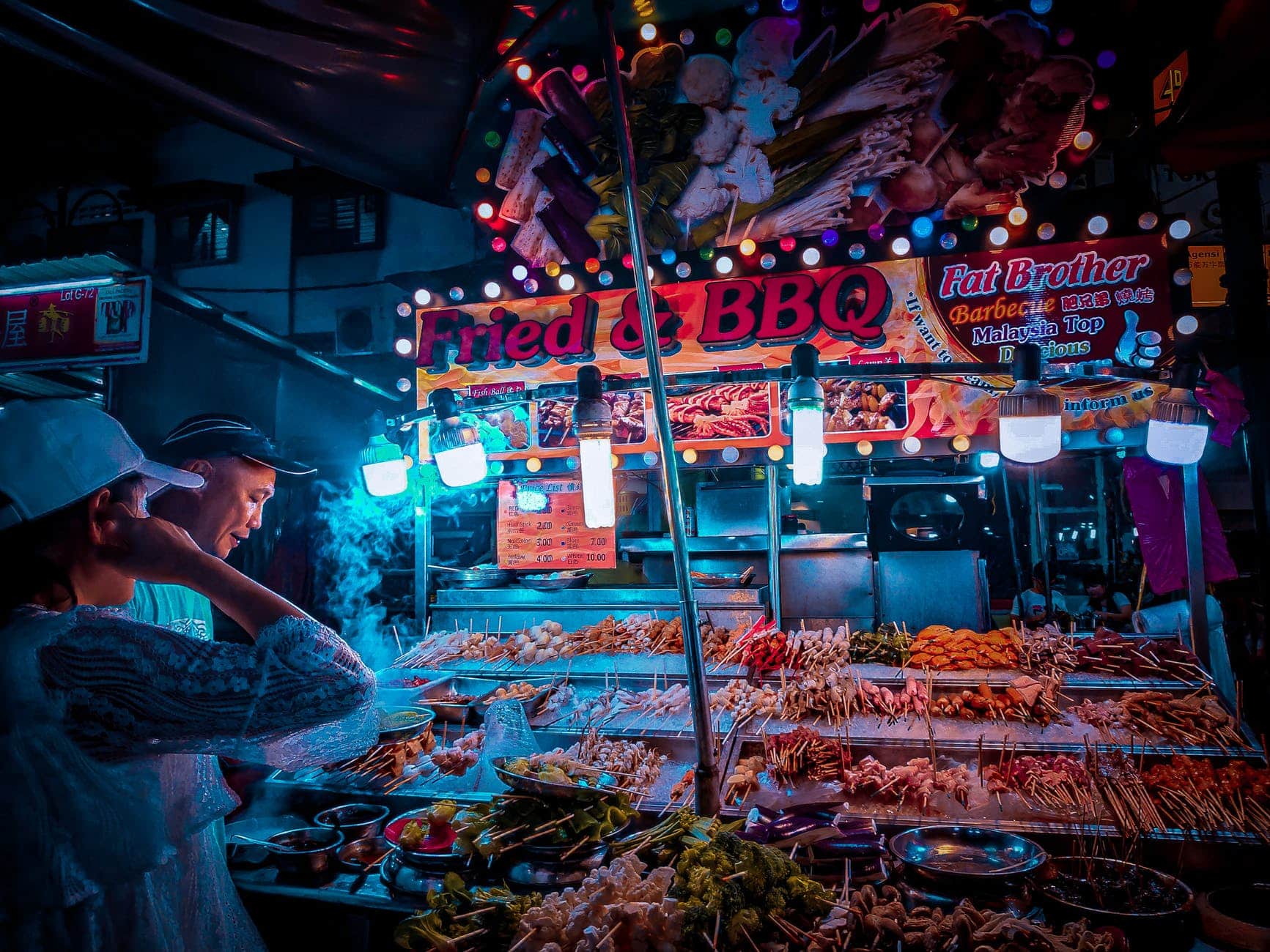 customer choosing raw kebab in street stall at night