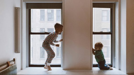 two kids playing beside glass windows