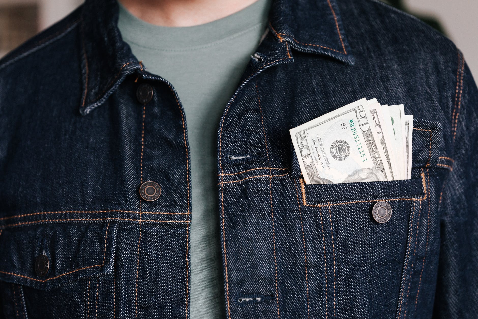 crop man with dollar banknotes in pocket of jacket