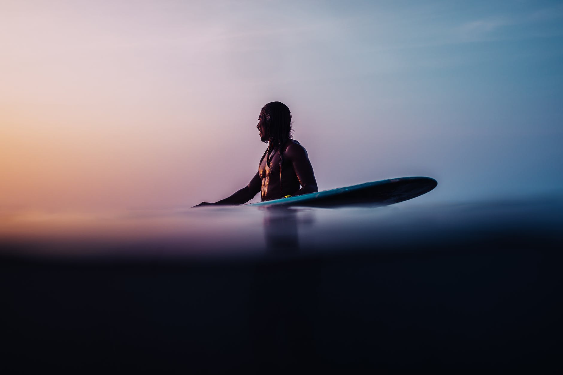 surfer with surfboard standing on sea shore