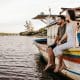 joyful couple sitting on old boat and holding hands